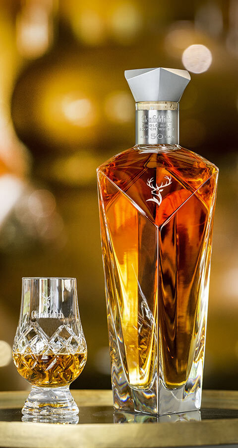 Glenfiddich 50 Year Old Single Malt Scotch Whisky bottle and glass on a bar