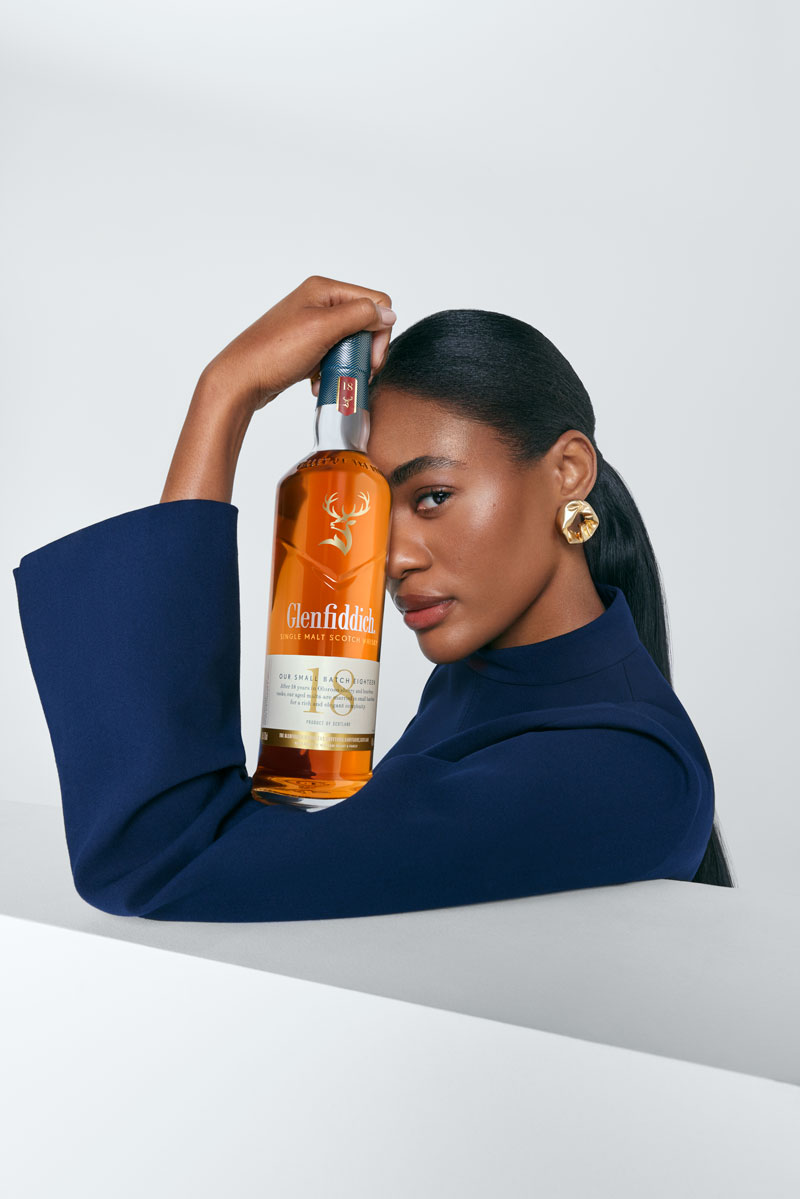 Woman holding bottle of Glenfiddich 18 Year Old Single Malt Scotch Whisky bottle