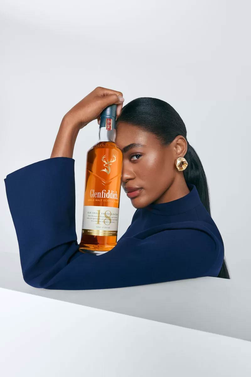Woman holding bottle of Glenfiddich 18 Year Old Single Malt Scotch Whisky bottle