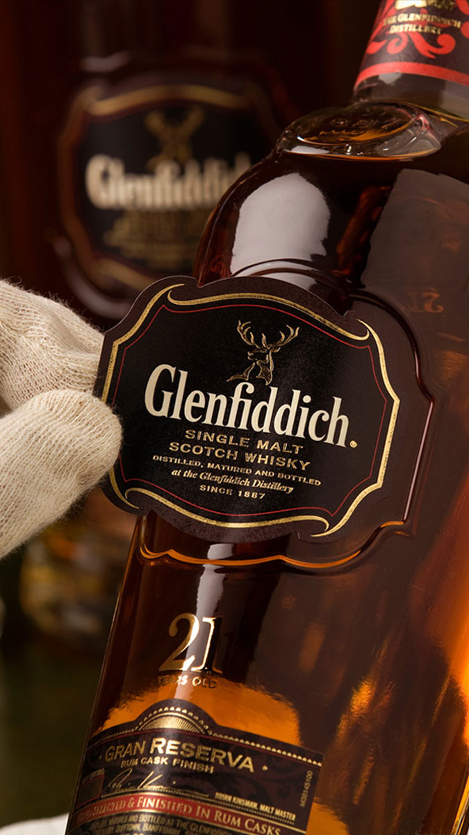 Man placing label on Glenfiddich bottle