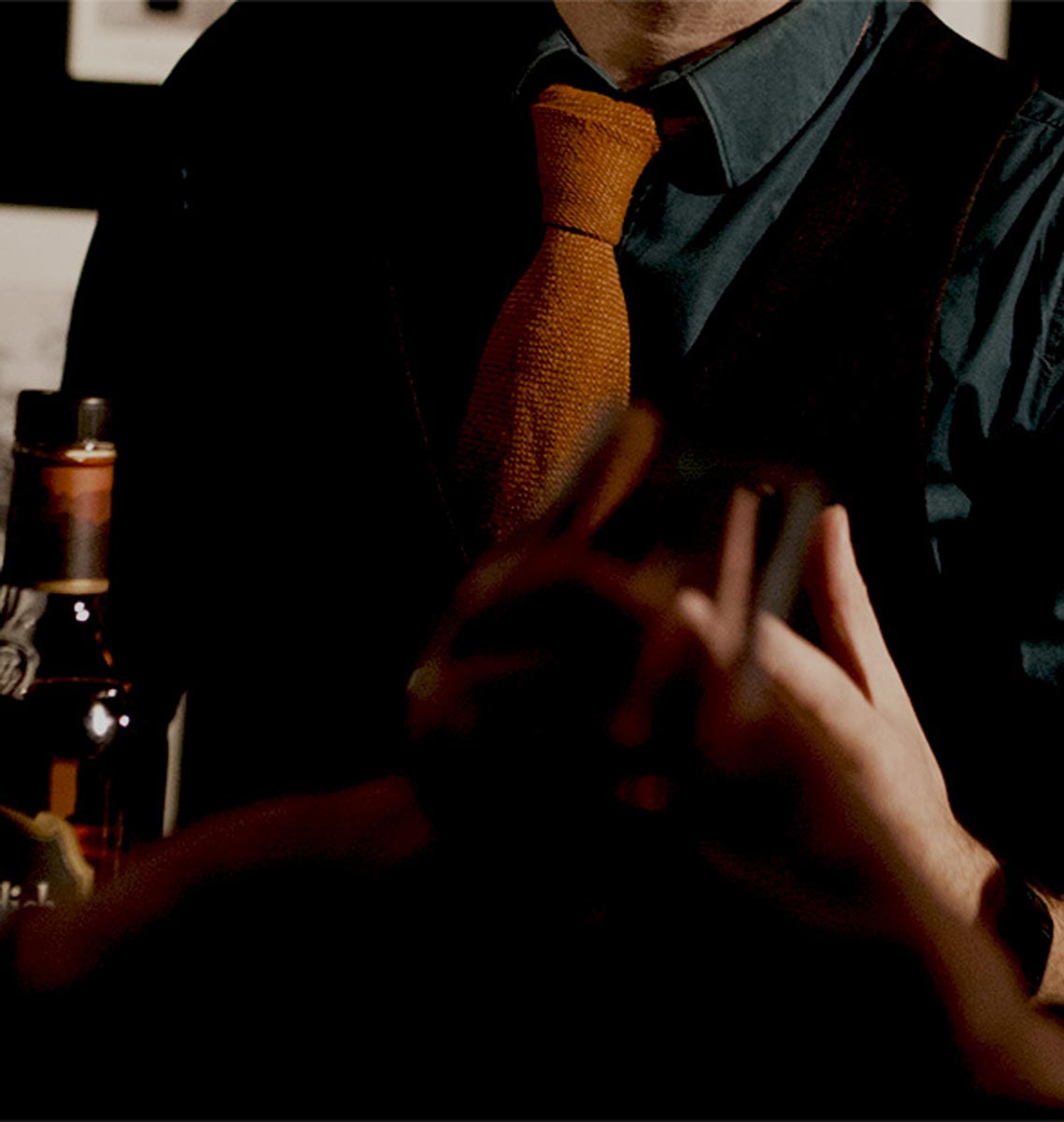 Man in shirt and tie holding whisky bottle 
