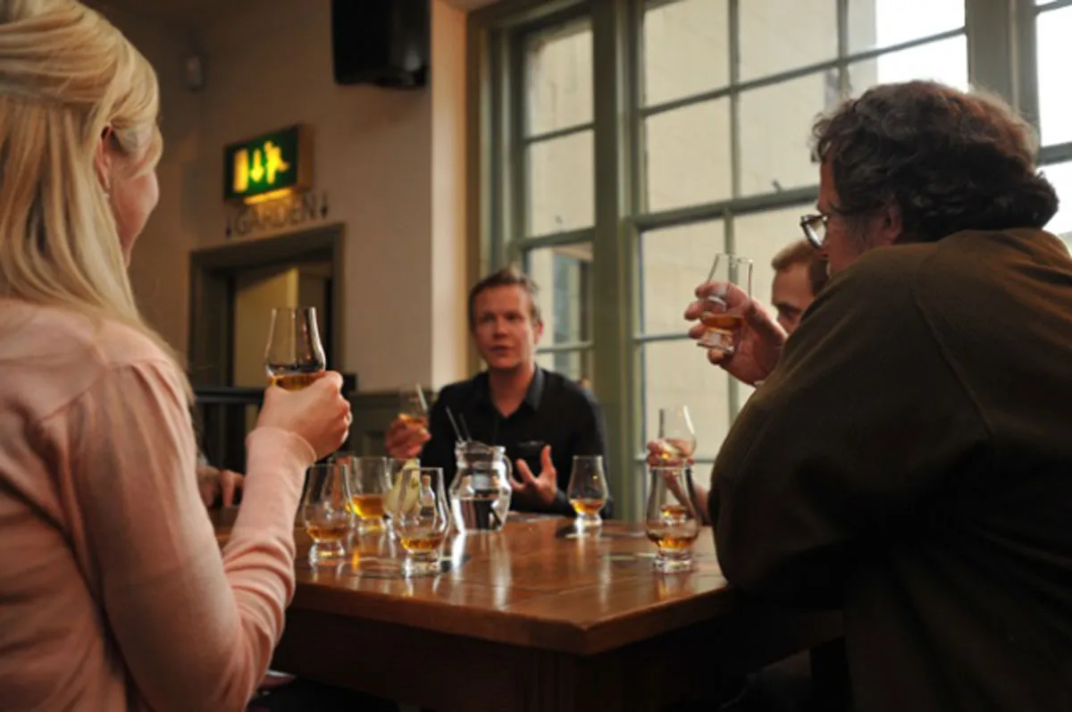 Four people sitting at a table with whisky drams