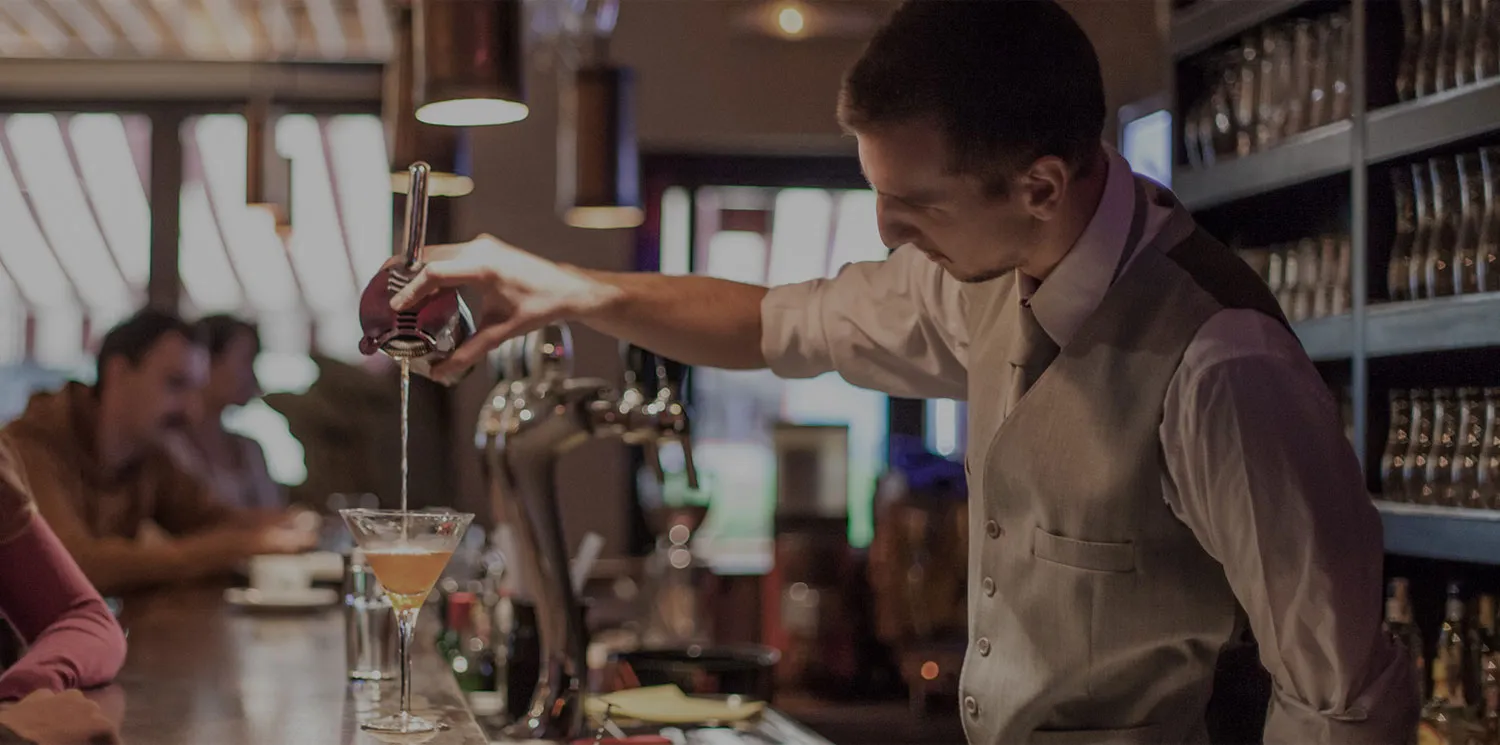 Barman pouring a cocktail