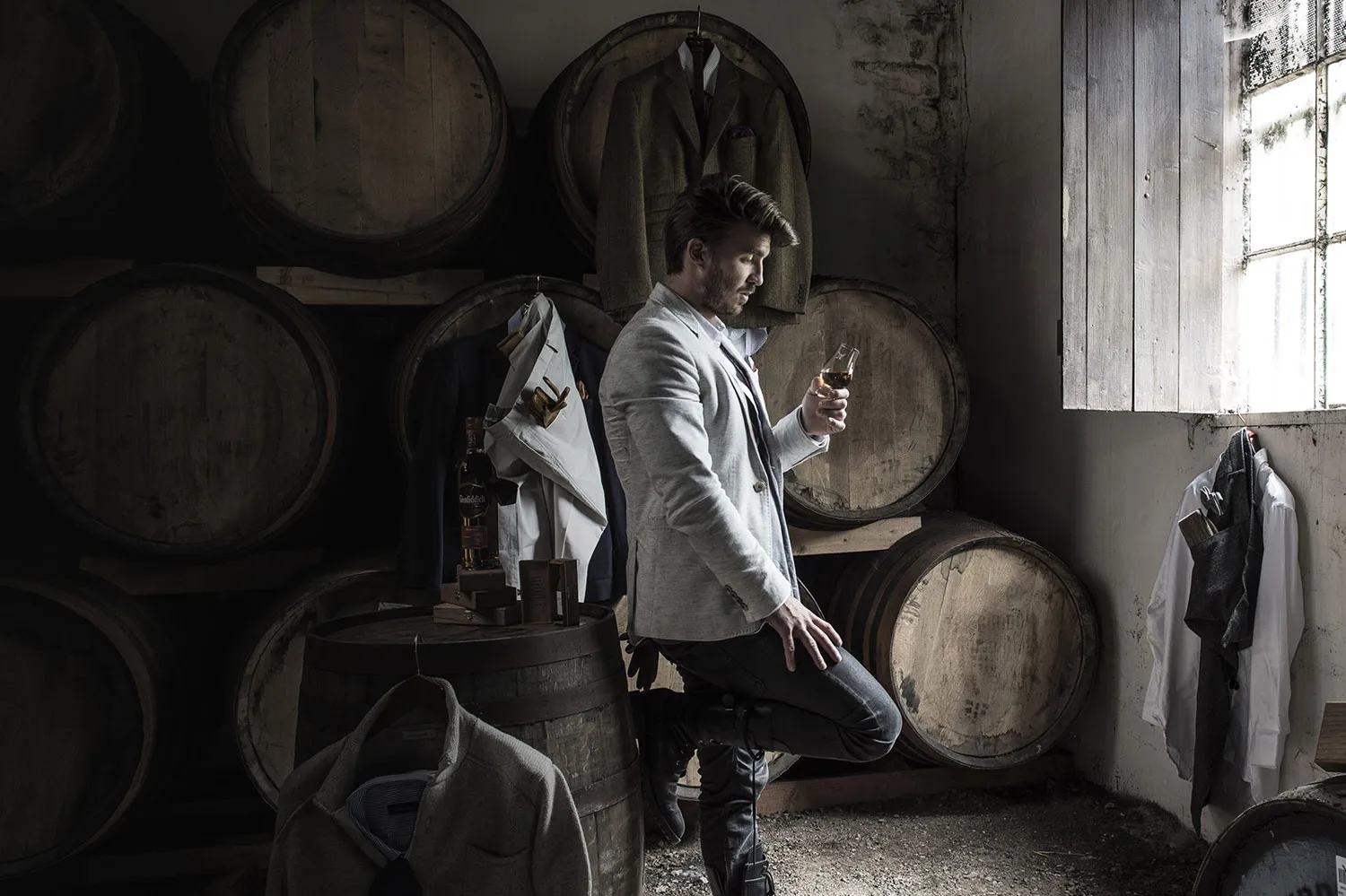 Man in suit inspecting dram of whisky